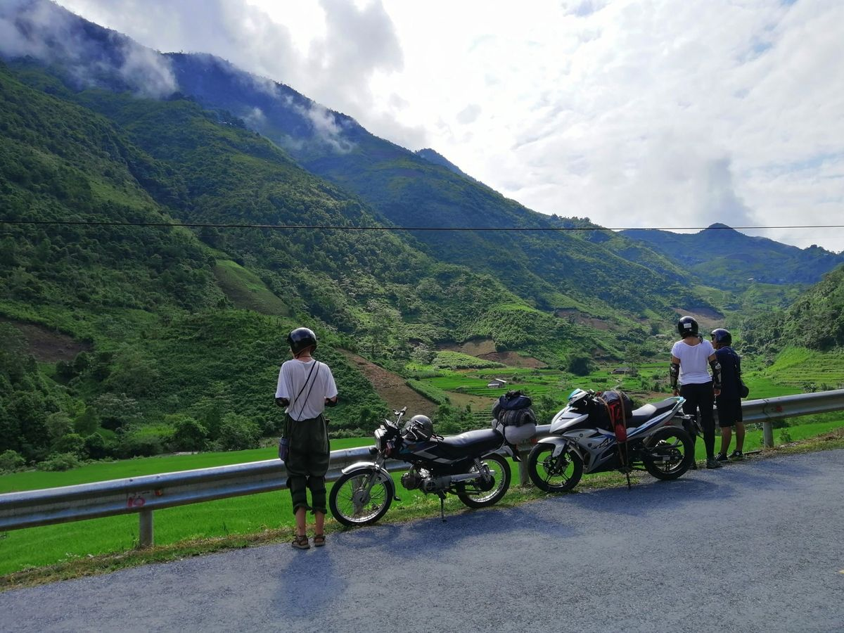 Travelers on a motorbike trip admiring the majestic mountain scenery in Ha Giang with Phieu Travel