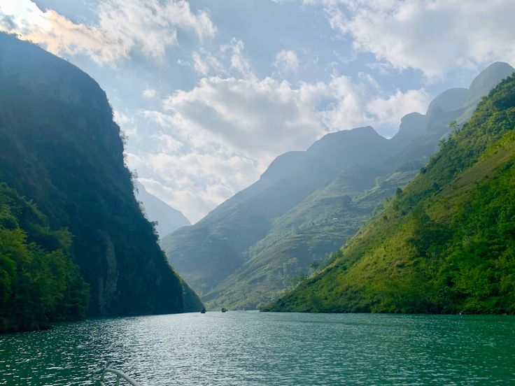 From the viewpoint of a boat, the Nho Que River stretches like a ribbon of vibrant emerald green
