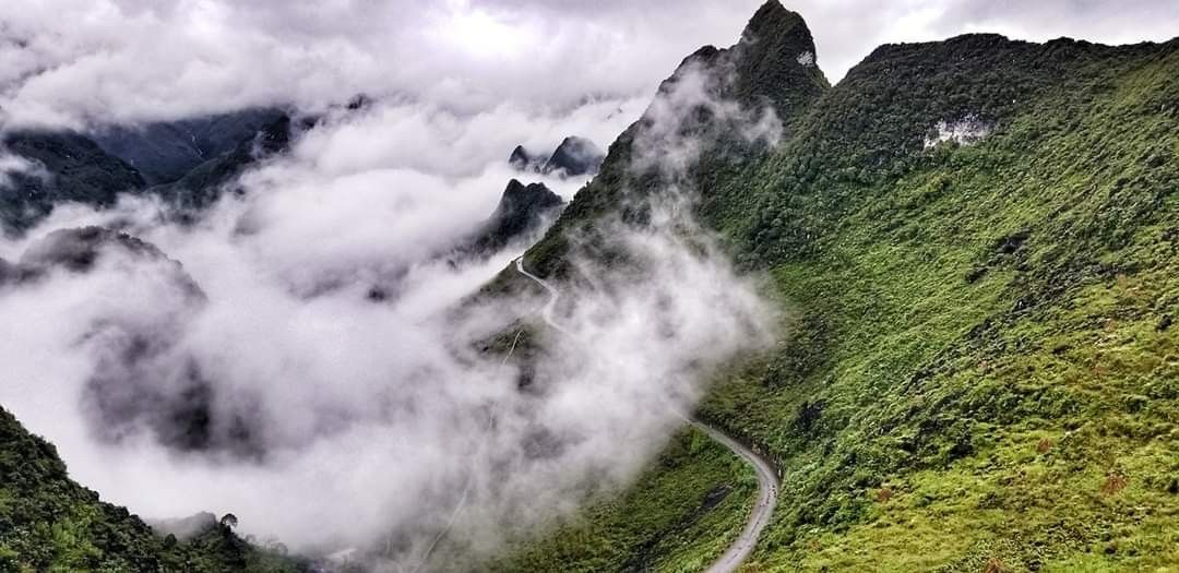 The image is a majestic panoramic view of the Ma Pi Leng Pass in Ha Giang, Vietnam