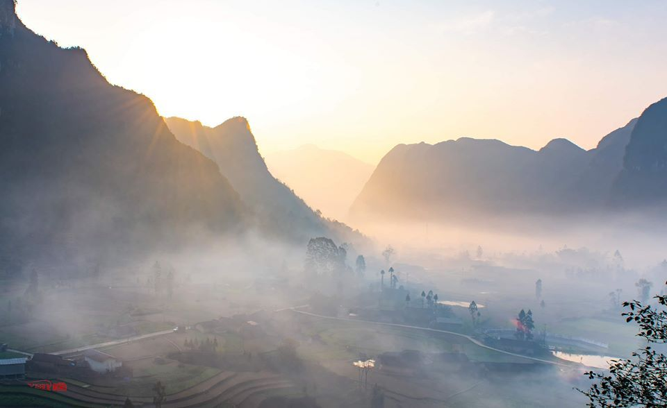 Cloud Hunting in the Ha Giang at sunrise as golden light pierces misty limestone mountains and terraced valleys below